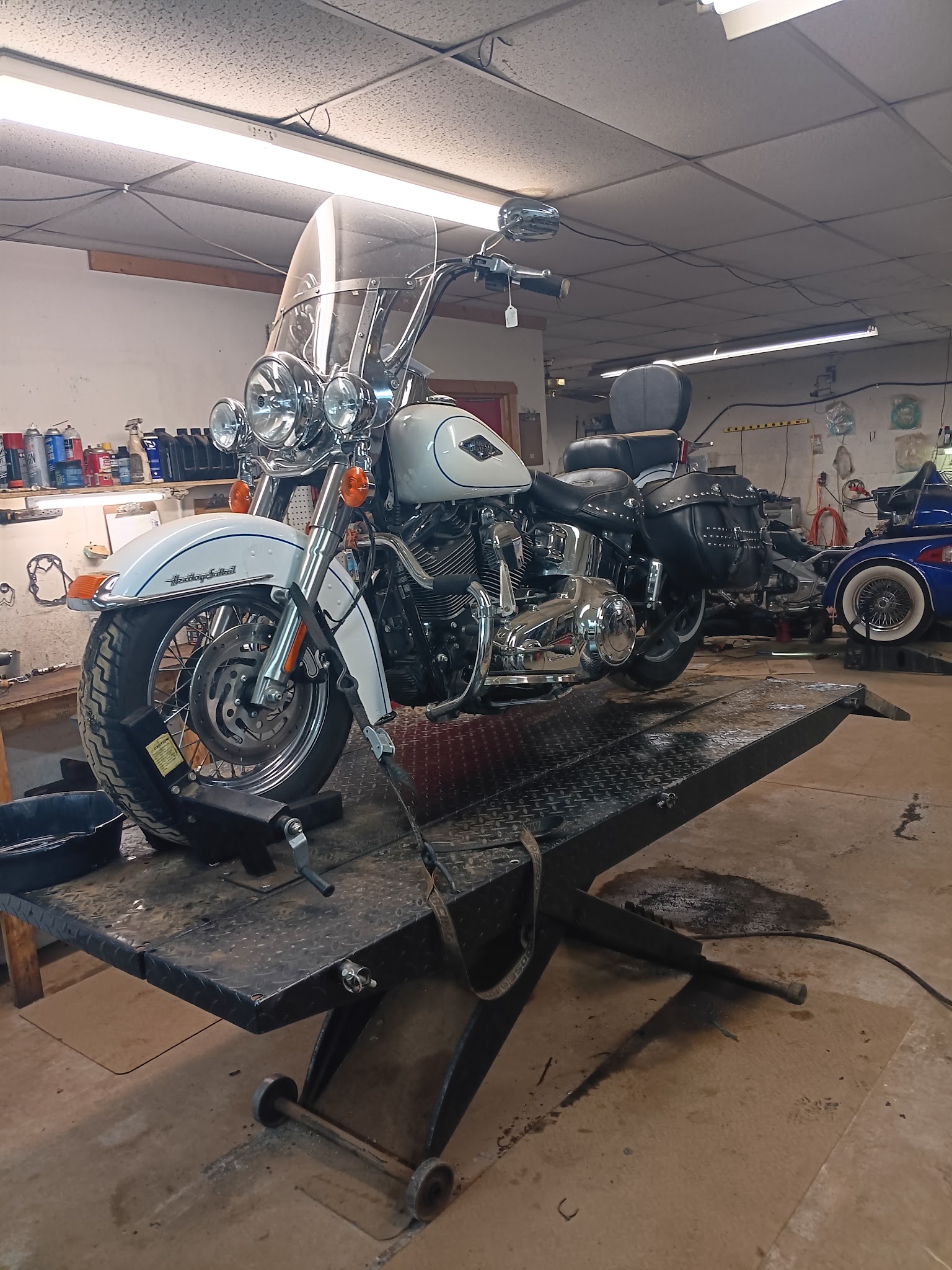 White Harley-Davidson Heritage Softail on the motorcycle lift inside the shop