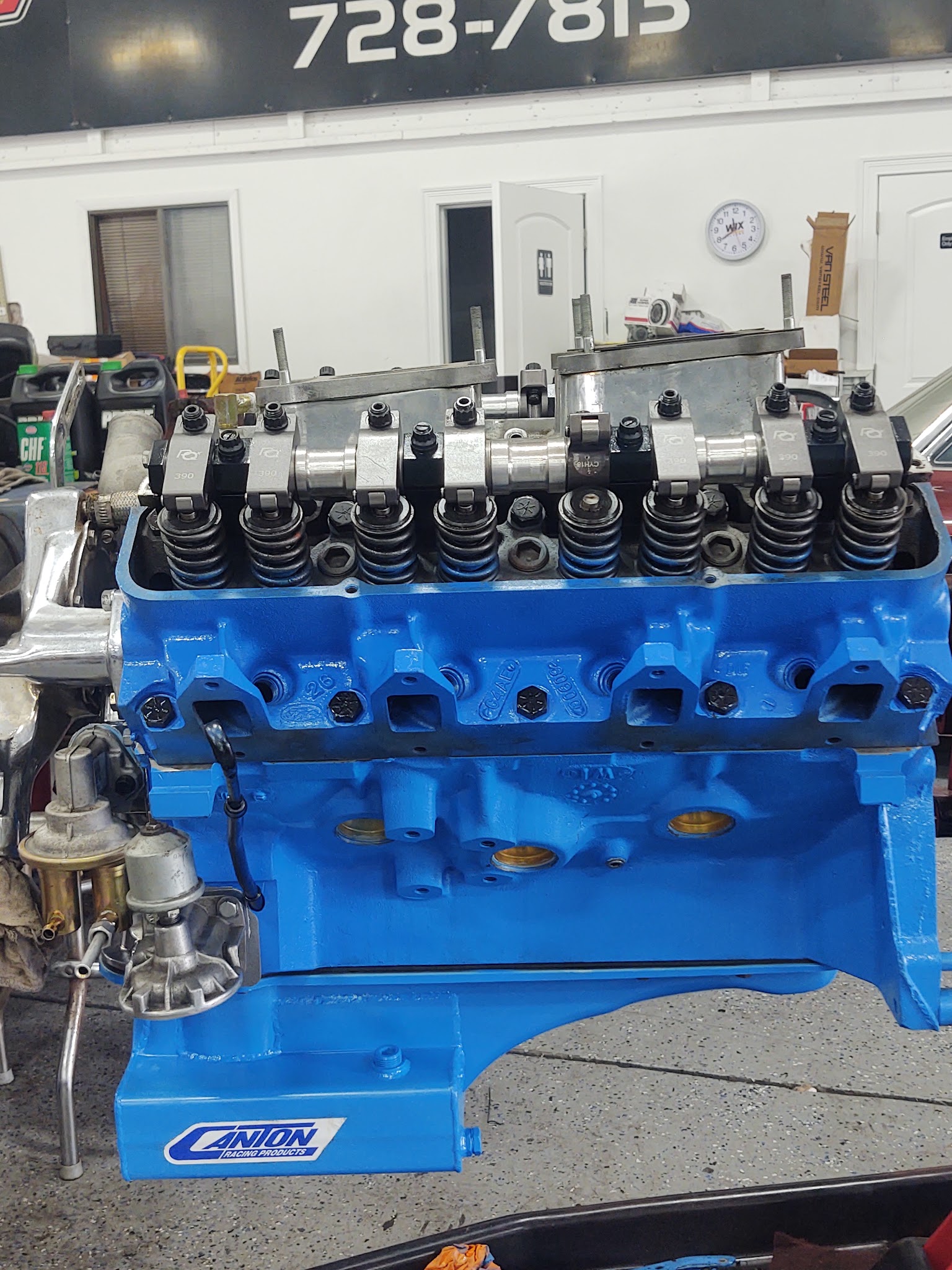 Freshly painted blue Ford engine block with Canton Racing oil pan on the workbench
