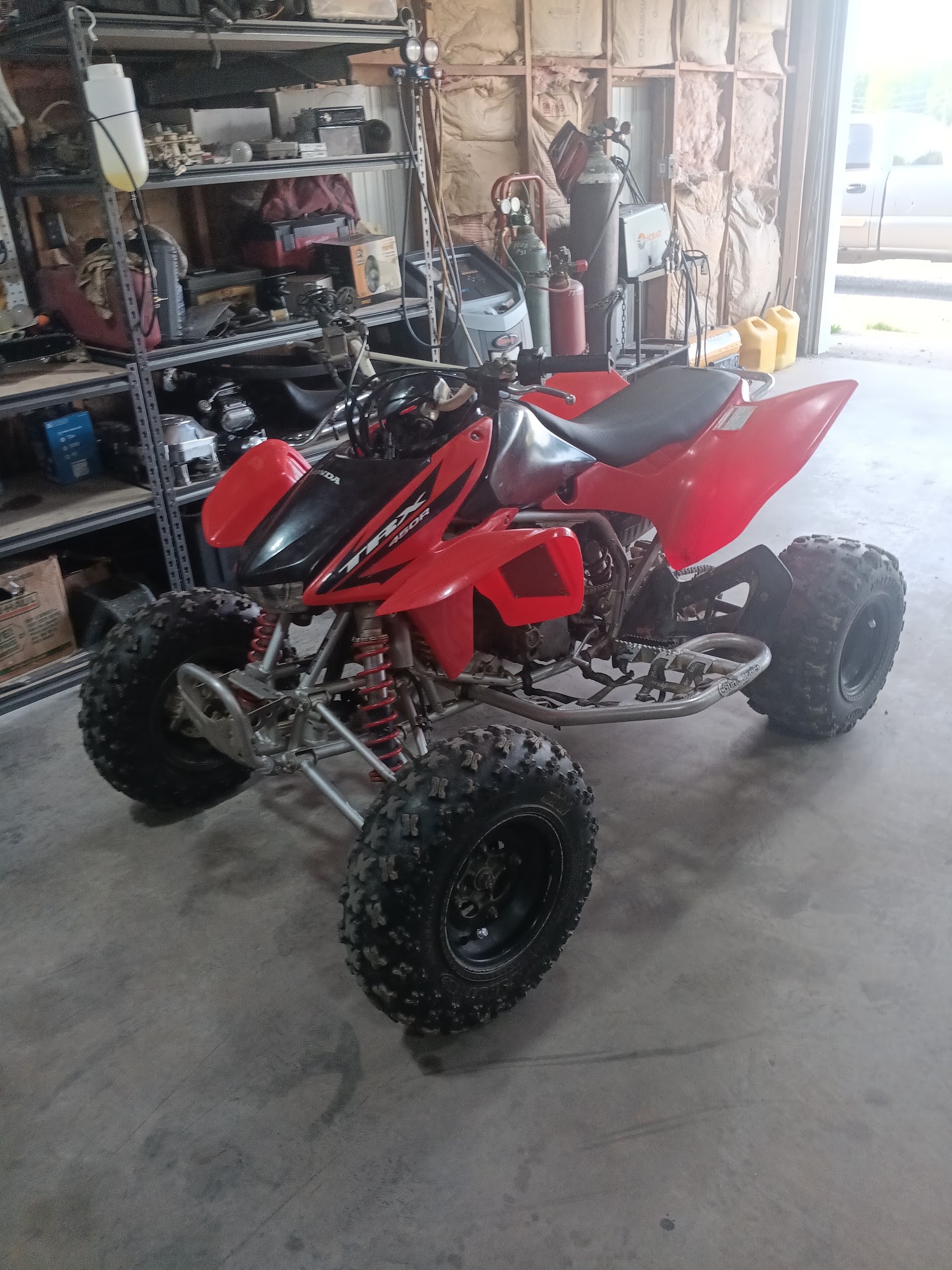 Red Honda TRX 450R sport ATV in the shop ready for service