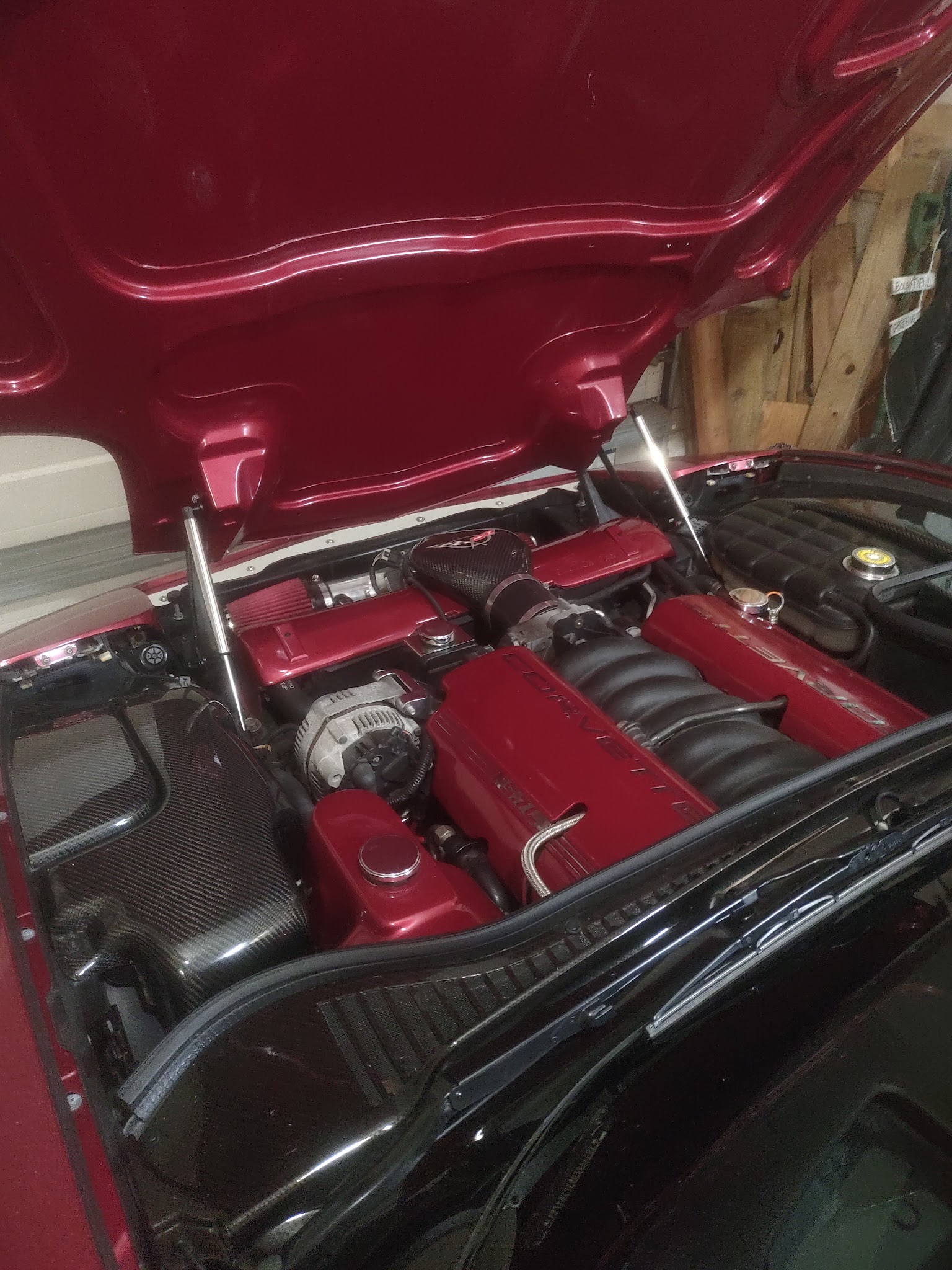 Corvette engine bay with red valve covers, carbon fiber airbox, and detailed engine work