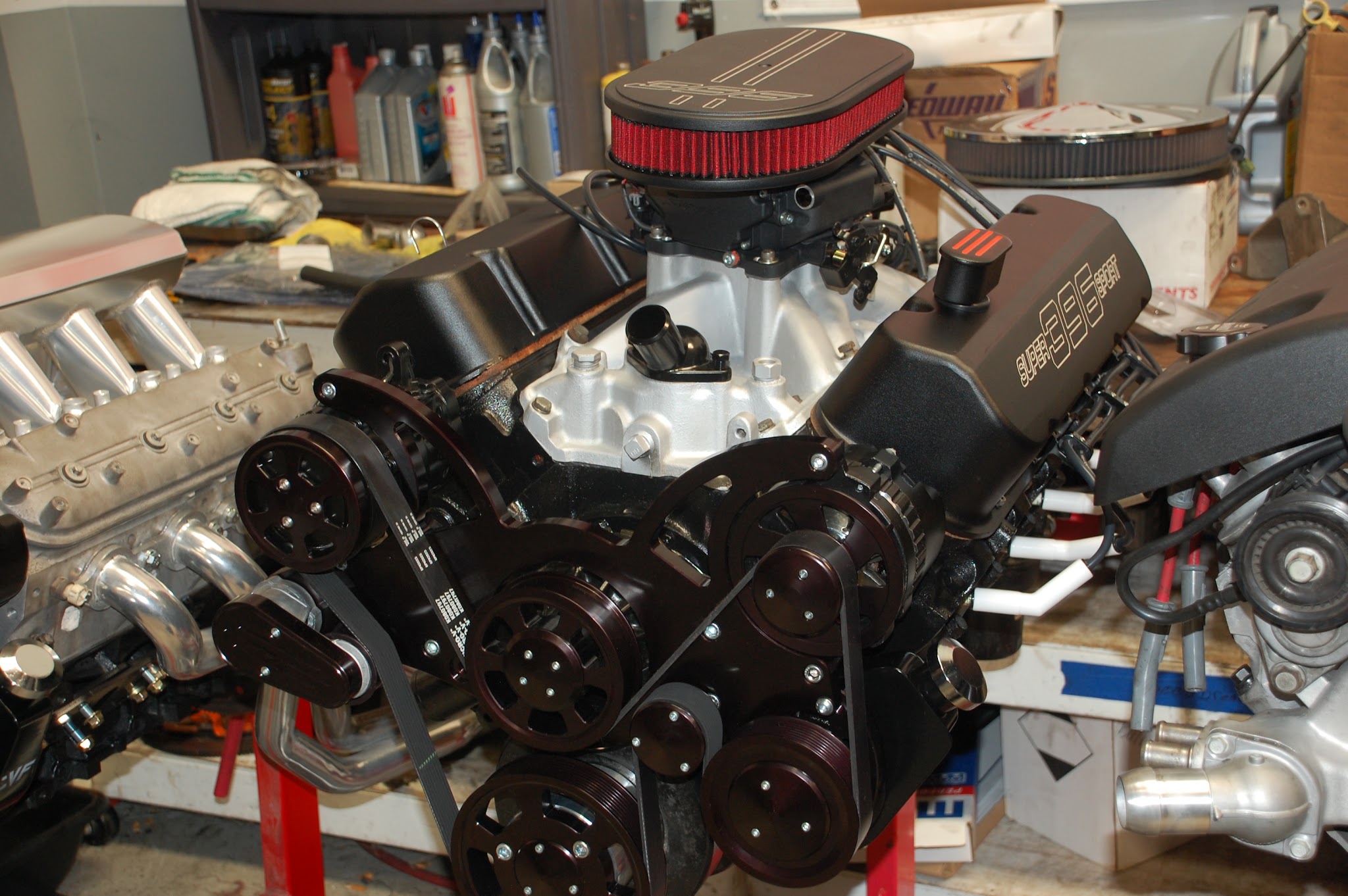 Chevy 396 Super Sport engine on stand with serpentine setup and air cleaner in the shop